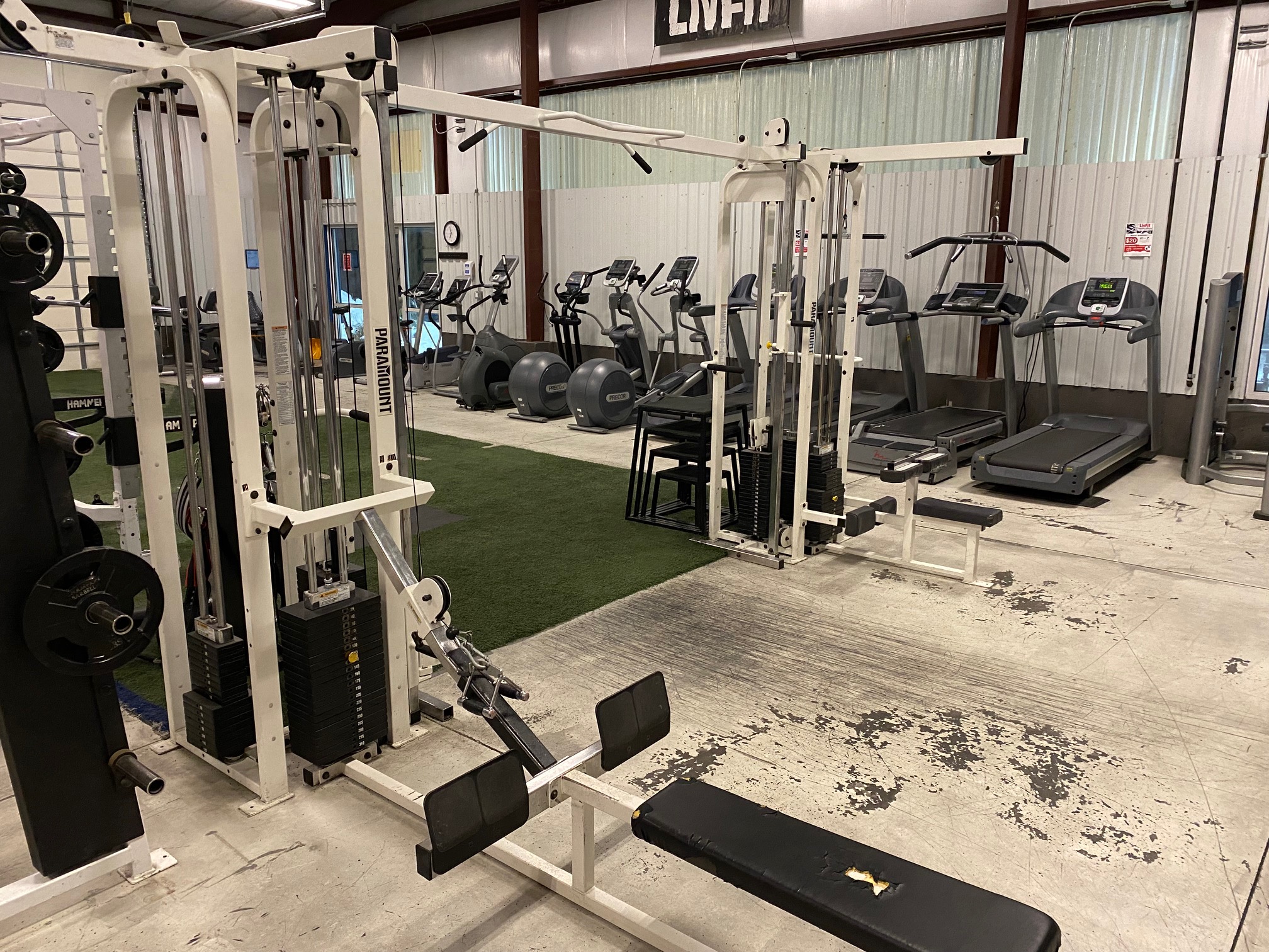 Large exercise rack with pullup bars, rowing station, and cables.