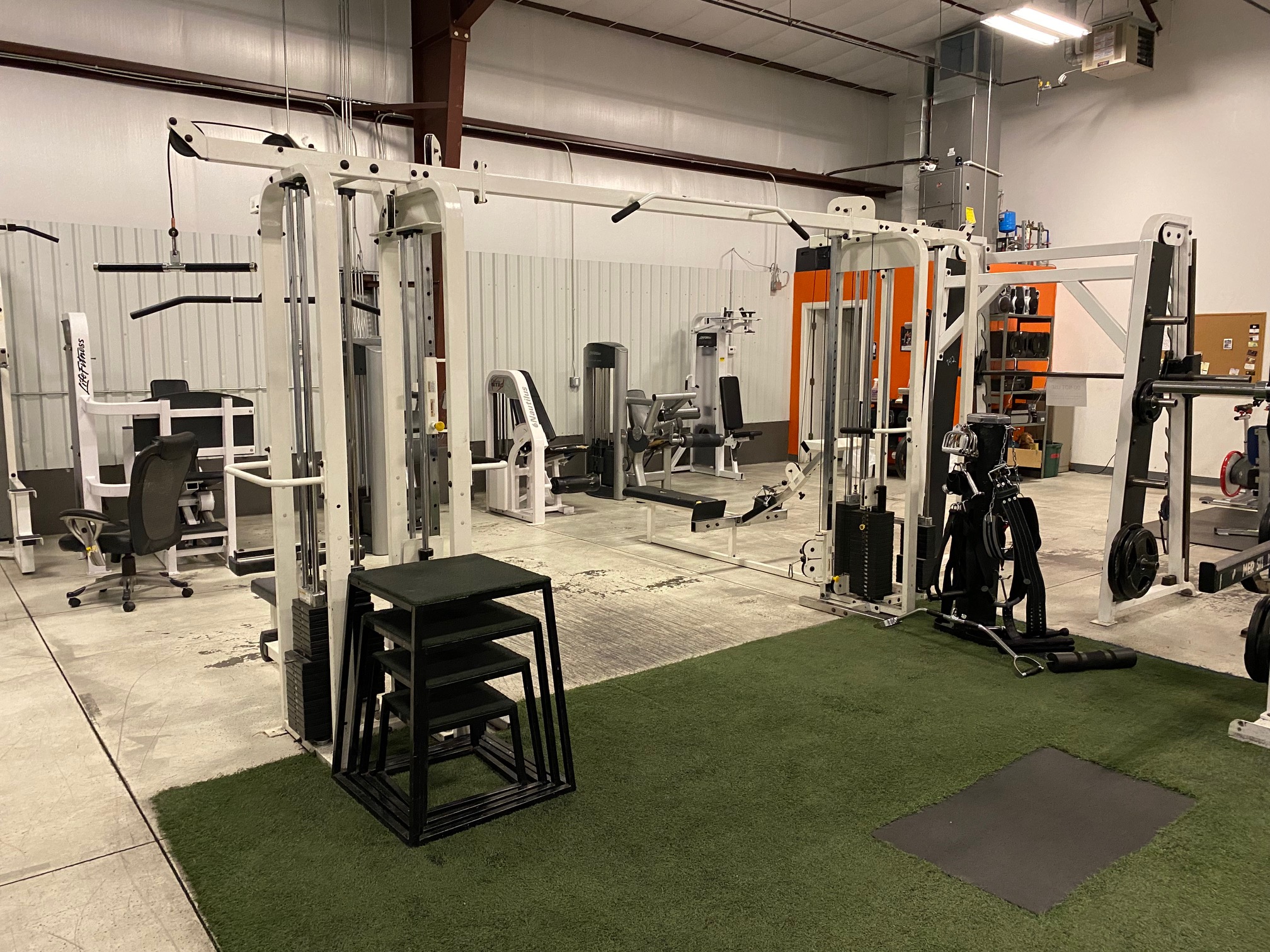 Exercise rack with pullup bars and cables with jumping boxes.