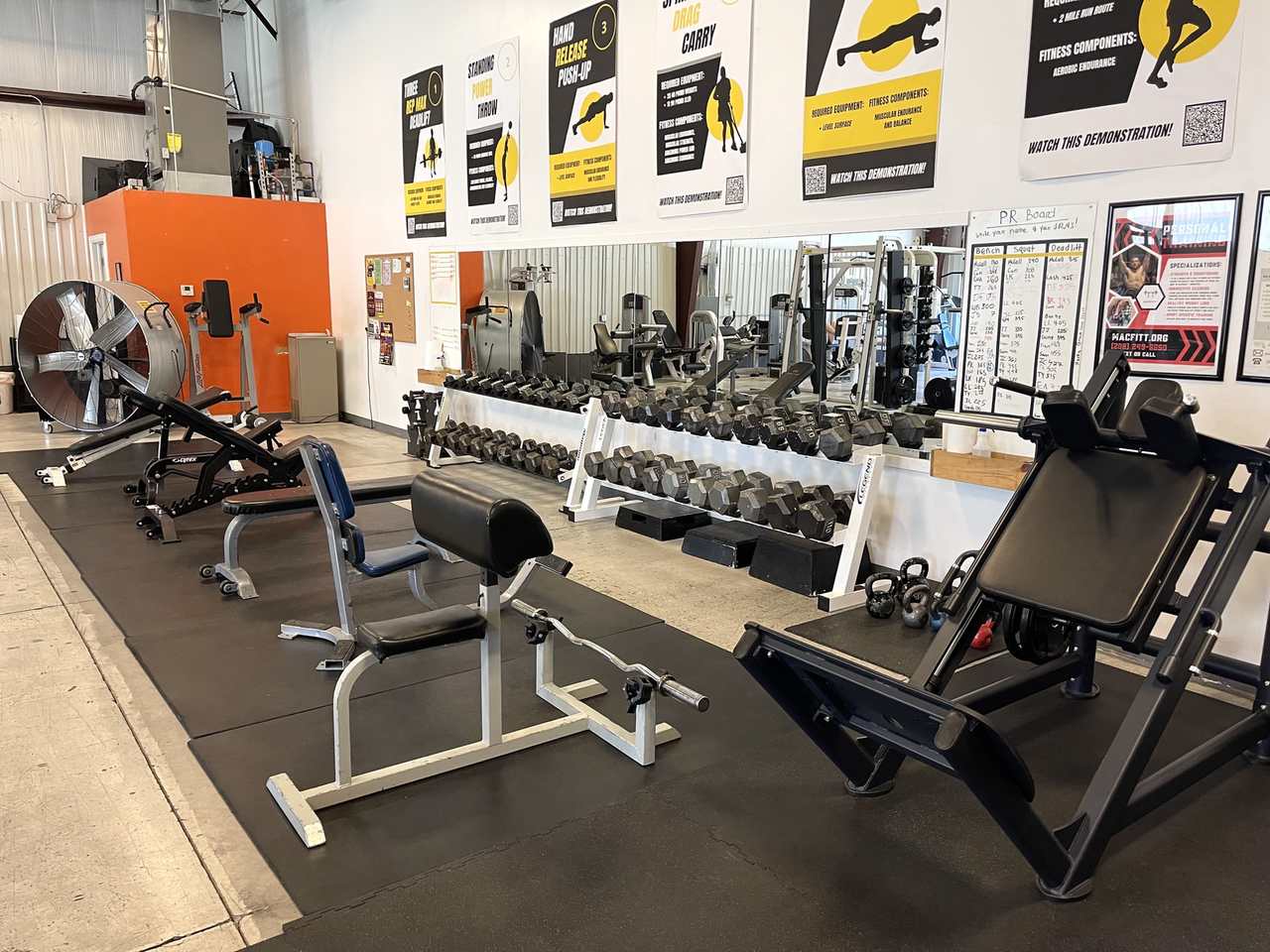 Preacher curl bench with dumbbell racks.